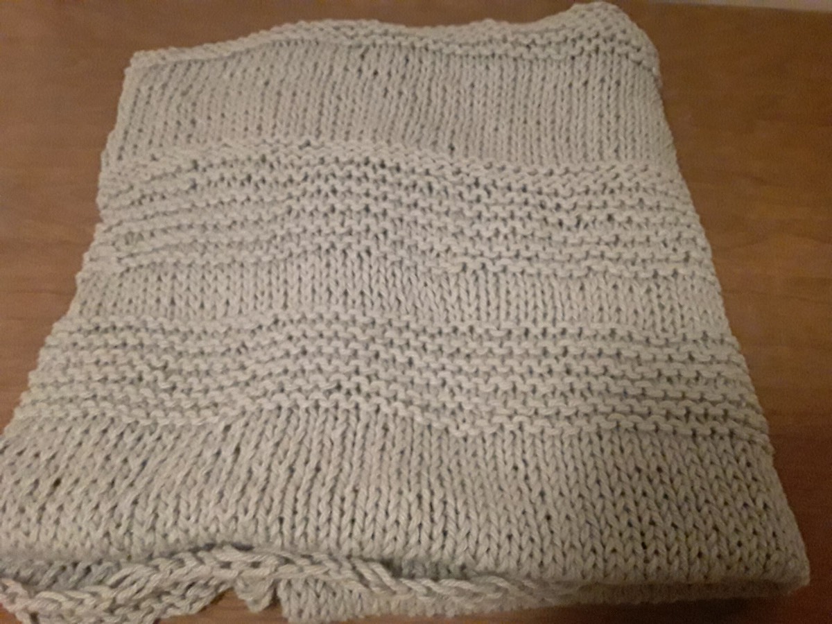 A folded grey knitted blanket