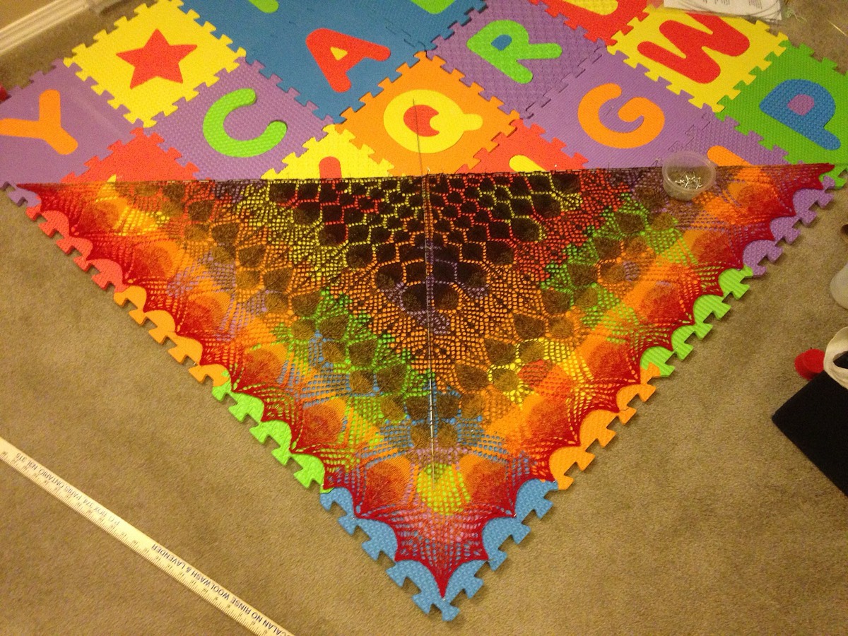 A knitted lace piece pinned out on blocking mats